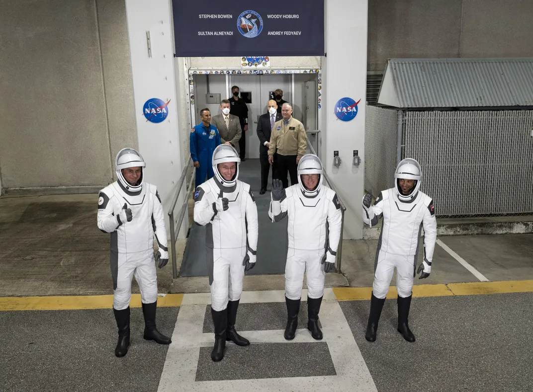 Four astronauts in space suits standing together