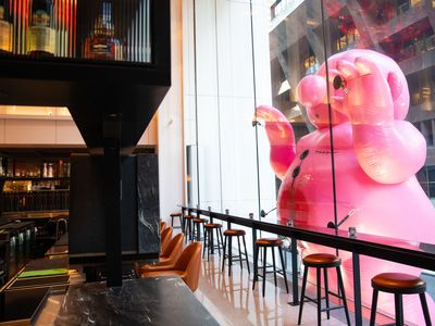 A pink man looking into a bar at the Vermillion Club&nbsp;in Boston