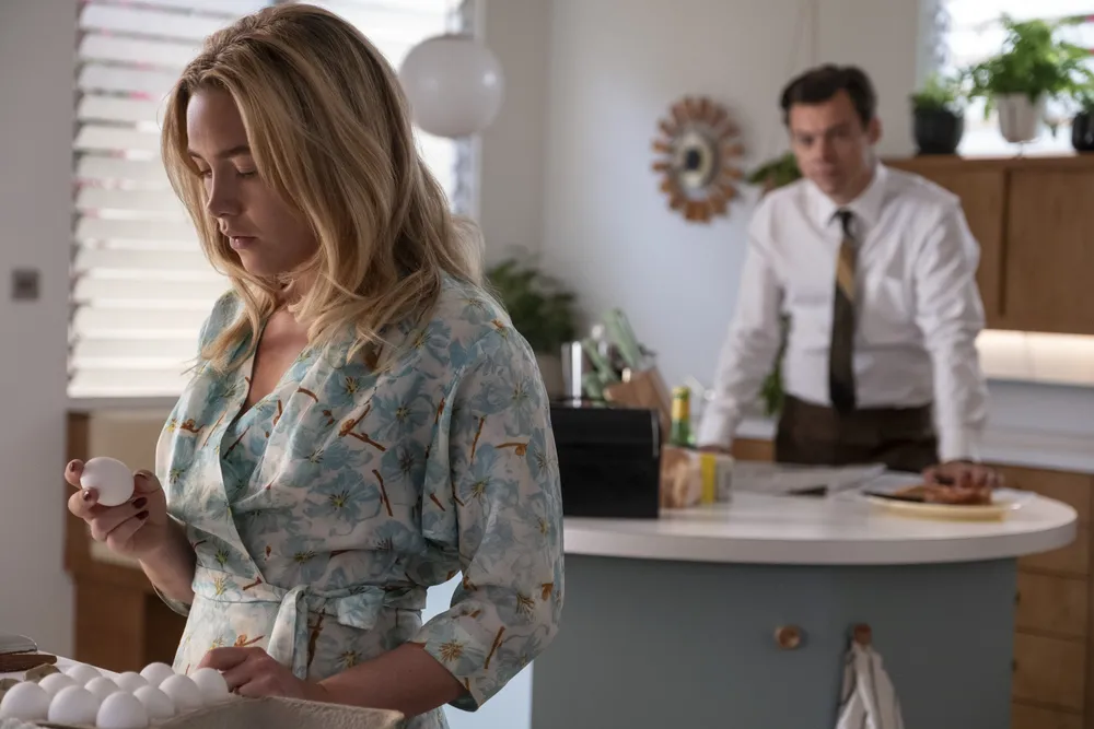 Florence Pugh (left) stars in Don't Worry Darling as Alice, a 1950s housewife who resides in an idyllic California community with her husband, Jack (Harry Styles, right).