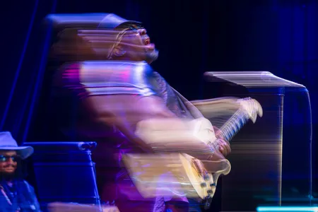 A man on a stage plays a guitar.