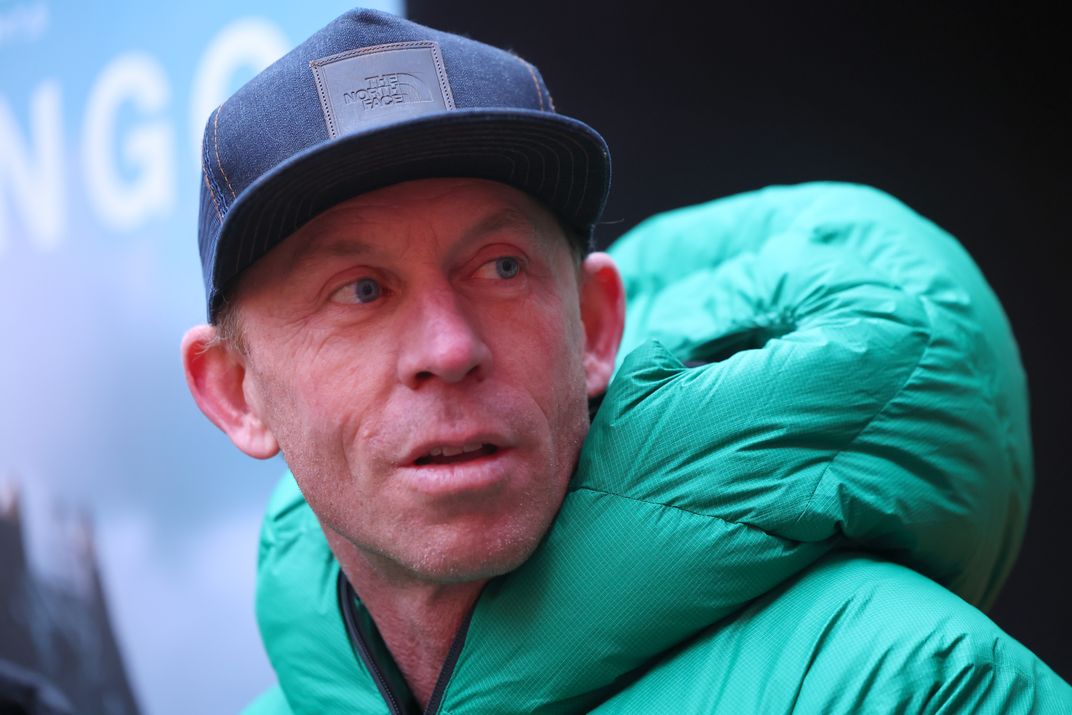 A man wearing a hat and a green coat
