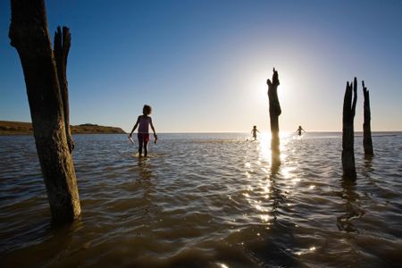 Teens from the Njarainjari Aboriginal Community walk in the shallows of Lake Albert in Southern Australia