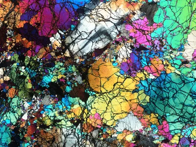 A thin slice of the ancient rocks collected from Gakkel Ridge near the North Pole, photographed under a microscope and seen under cross-polarized light