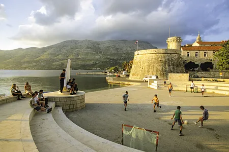 Youngsters play soccer near a fort at the port of Korčula, which once served as the arsenal of the Venetian Empire in the Adriatic.