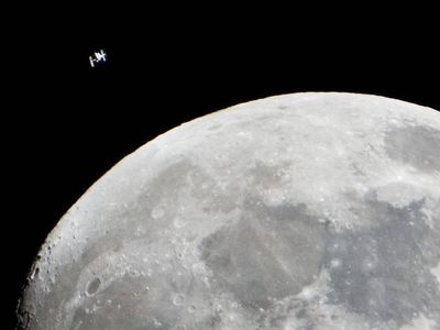 The International Space Station can be seen as a small object in upper left of this image of the moon in the early evening Jan. 4 in the skies over the Houston area flying at an altitude of 242.8 miles. 