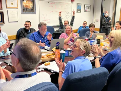 Members of the Voyager 1 flight team celebrate after receiving health and status data from the spacecraft. Next, engineers need to enable the probe to start sending science data again.