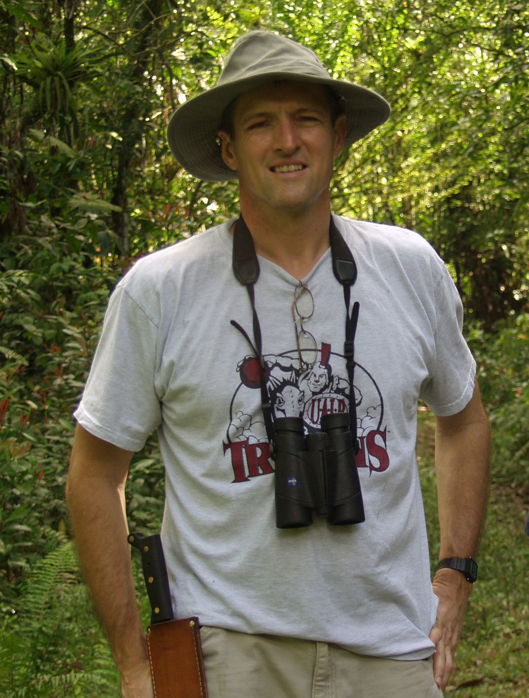 Man smiles for a picture in the woods.