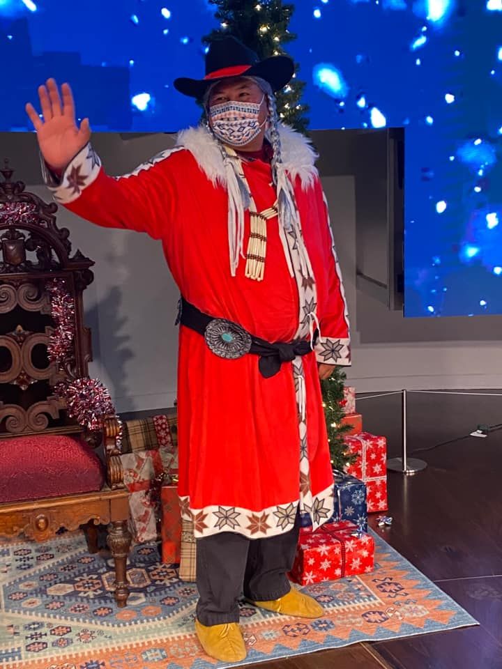 Photo of a person dressed as Santa Claus with Chickasaw accessories.