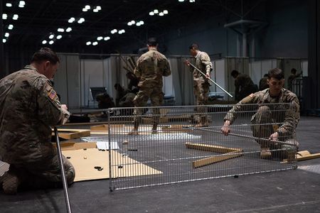 Soldiers assigned to the 531st Hospital Center build shelving at the Jacob K. Javits Convention Center in Manhattan, where a temporary medical station has been constructed to aid efforts combating the COVID-19 pandemic.