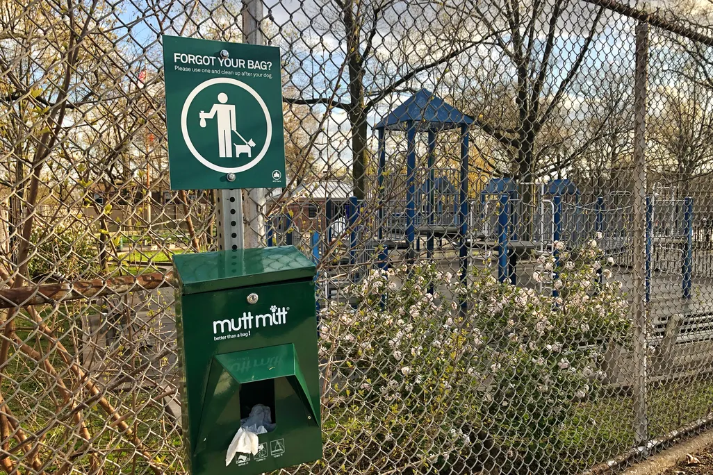 A container with dog waste pick up bags outside a park in New York City.