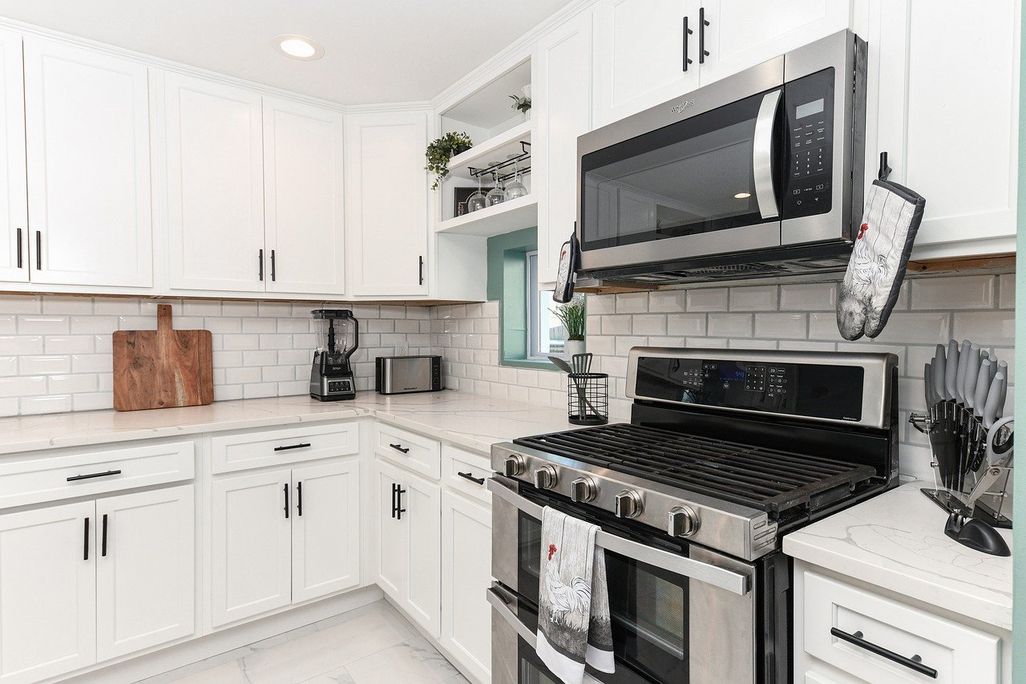 A microwave in a kitchen with white cabinets