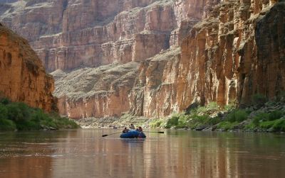 Canyon walls tower above river rafters in the cathedralesque Grand Canyon. Traveling by raft may be the most enjoyable and easiest way to explore the Colorado River, one of the most threatened rivers.