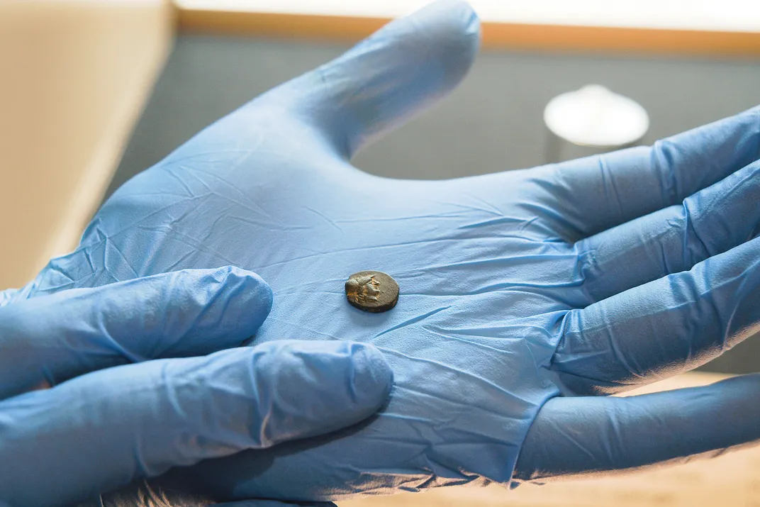 Bronze coin in a gloved hand