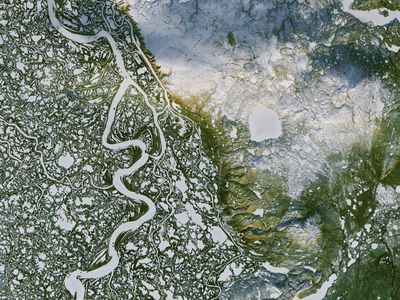 This NASA Landsat image shows the Mackenzie River surrounding the town of Inuvik, and the uniquely pock-marked landscape of this delta. 