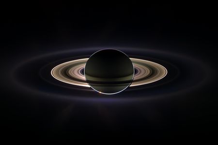 Saturn as seen by Cassini:  Some of you dust particles aren’t from around here, are you?