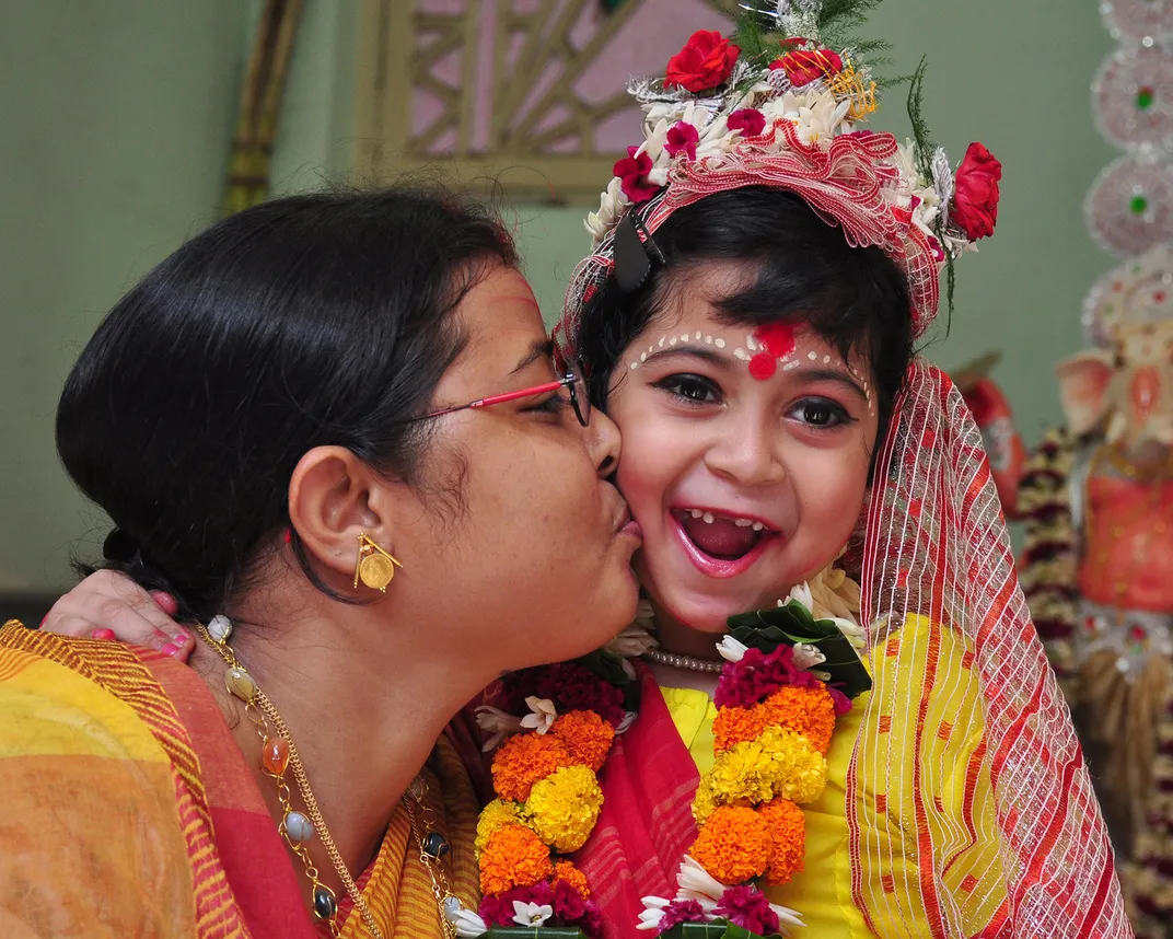 3 - A mom and daughter share a touching moment as they celebrate the Durga Puja festival, which pays homage to the Hindu goddess Durga.