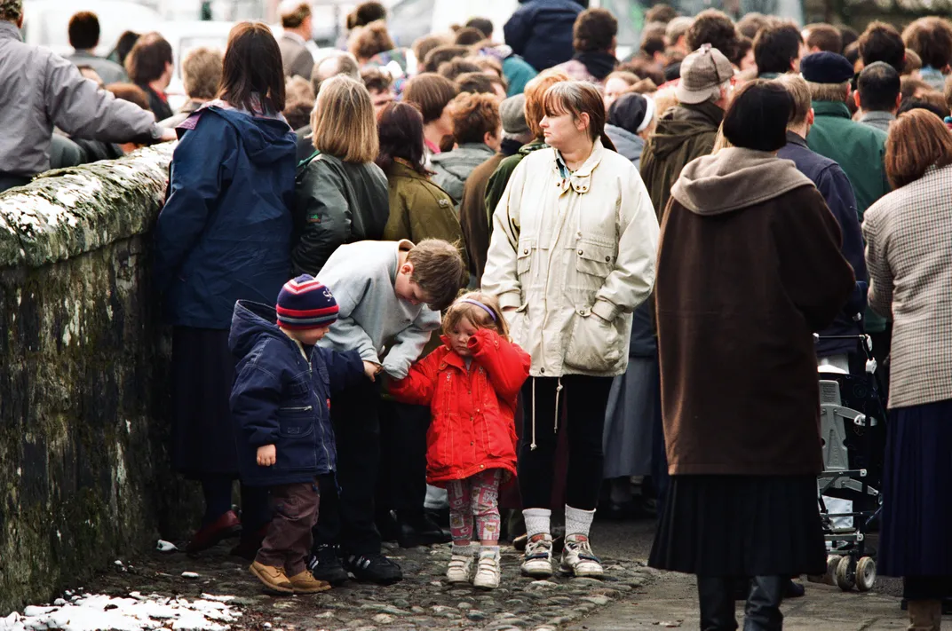 Children and adults gather outside of Dunblane Primary School shortly after the shooting