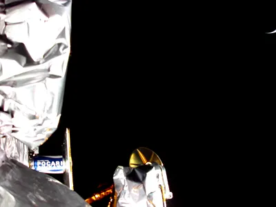 A photo from a camera on one of Peregrine&#39;s payload decks shows some of the spacecraft&#39;s payloads, as well as a sliver of Earth in the upper right.