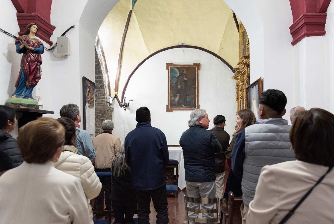 People standing in front of painting on the wall