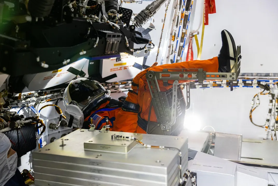 Mannequin wearing an orange spacesuit in a