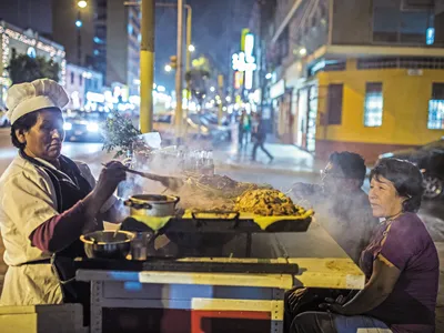 A Lima street vendor dishes up anticucho, grilled skewers that are traditionally prepared with marinated beef heart or tongue. It is a culinary tradition probably started by enslaved Africans here during the Spanish colonization.
