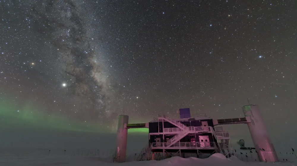 IceCube Lab with a starry night sky showing the Milky Way and faint green auroras