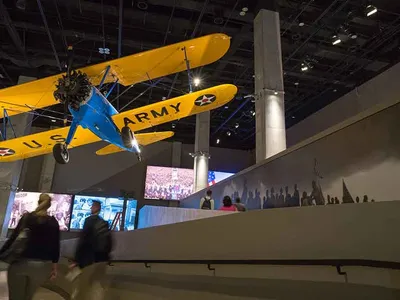 The “Spirit of Tuskegee” hangs from the ceiling at the Smithsonian’s National Museum of African American History and Culture. The blue and yellow Stearman PT 13-D was used to train Black pilots from 1944 to 1946.