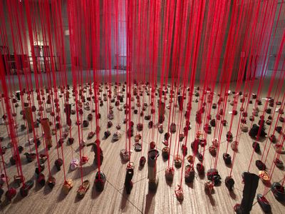 Japanese artist Chiharu Shiota tied red yarn to hundreds of unpaired shoes for "Perspectives," opening August 30 at the Arthur M. Sackler Gallery.