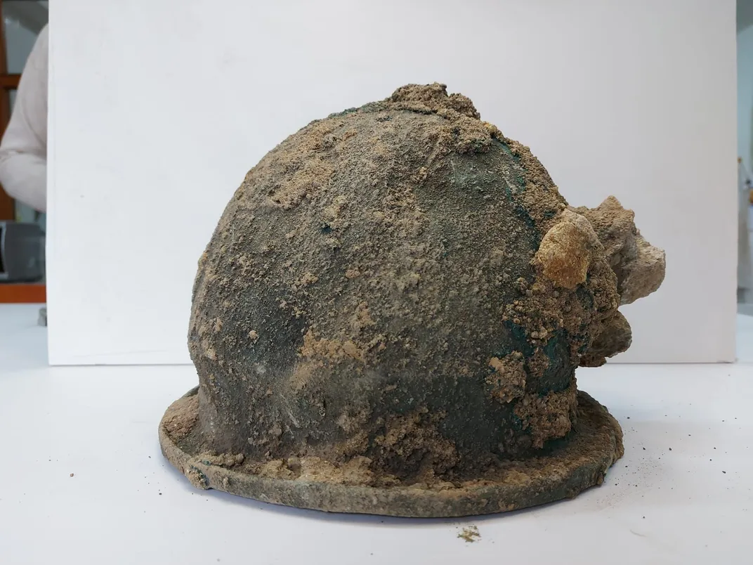 A helmet covered in lumpy brown dirt
