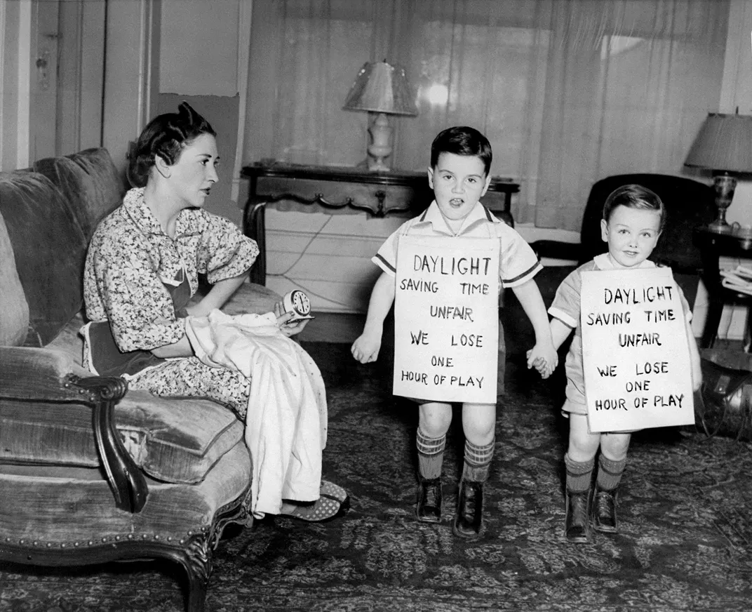 Children wearing signs protesting daylight saving time in 1939