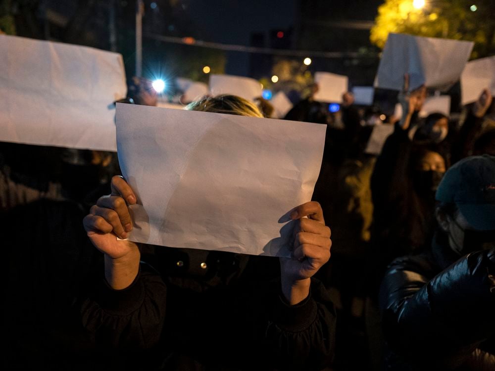 Protesters in Beijing hold up white sheets of paper during a November 27 protest against China's strict zero-Covid policy.