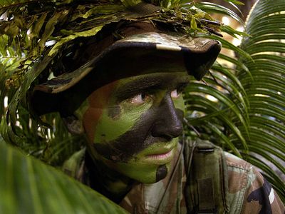 Airman 1st Class Nathan Fitzwater uses camouflaging and face point to maintain his cover at Anderson Air Force Base, Guam.