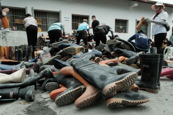 A pile of dirty workboots is being cleaned outside Guangfu Train Station. thumbnail