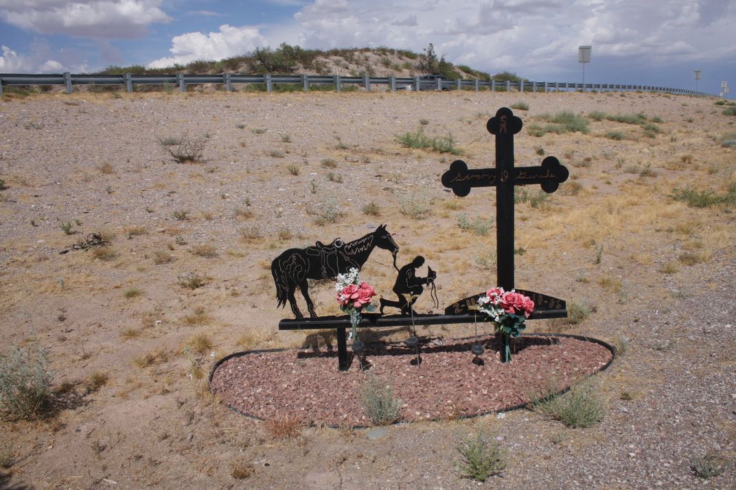 a memorial with cross in a desert landscape