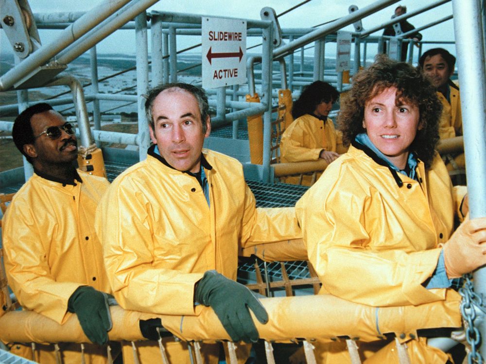 Ron McNair, Greg Jarvis and Christa McAuliffe in yellow training gear