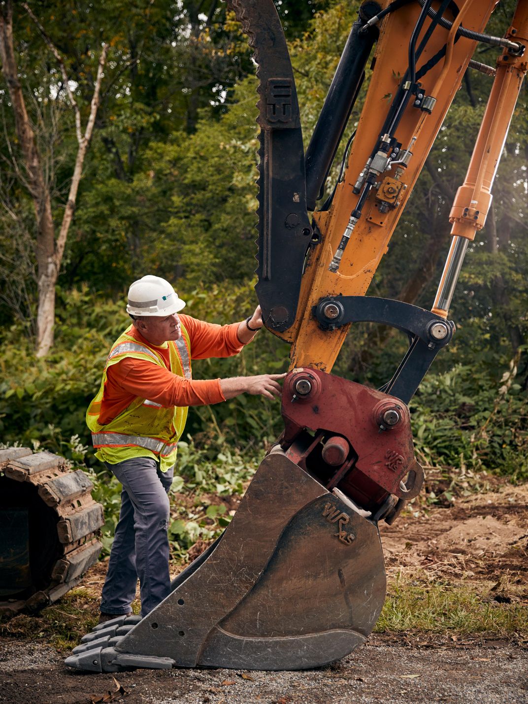 a construction worker inspects an excavator for lanternflie