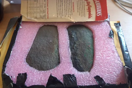 The sender carefully secured the ax heads inside a cardboard flapjack box.