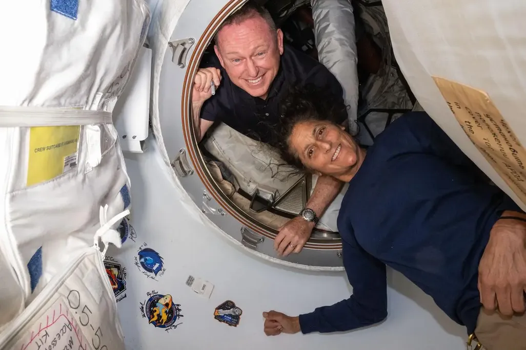 Two astronauts inside a spacecraft