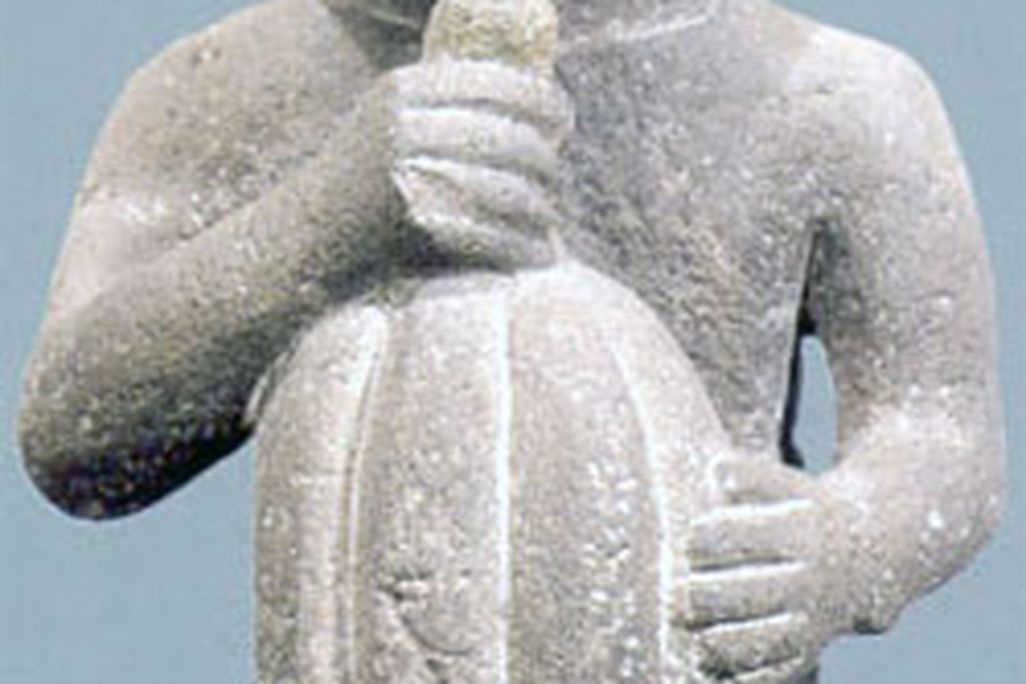 An Aztec figurine holds a cacao pod
