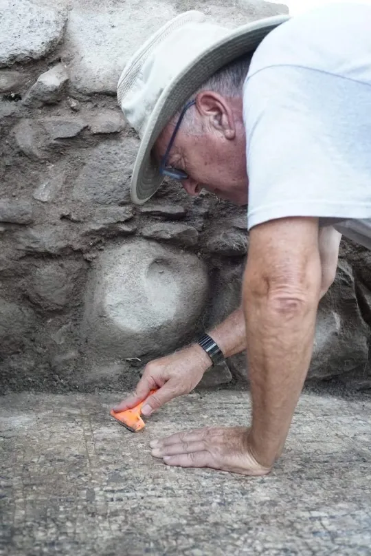 Archaeologist cleans incription