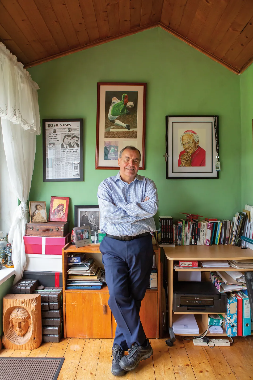 a man stands for a portrait in his home office