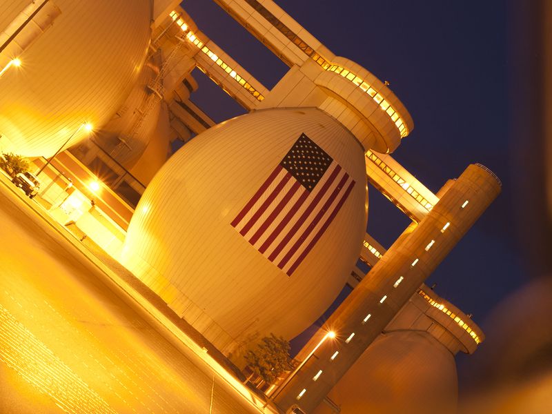 View through a chain link fence of an American Flag at water treatment