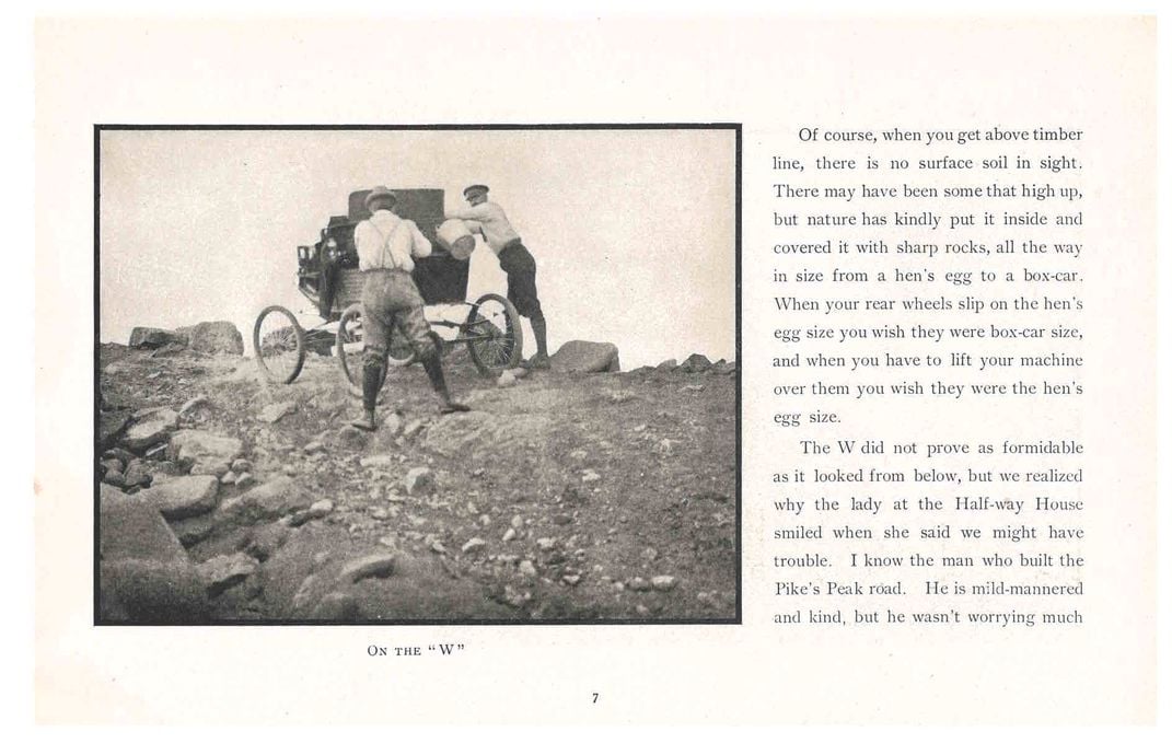 Trade catalog with photo of two men pushing locomobile through rocky terrain.