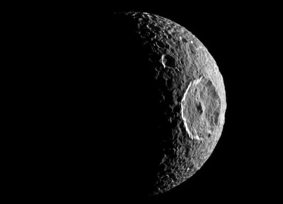 cratered moon in black and white with a large crater on its right side