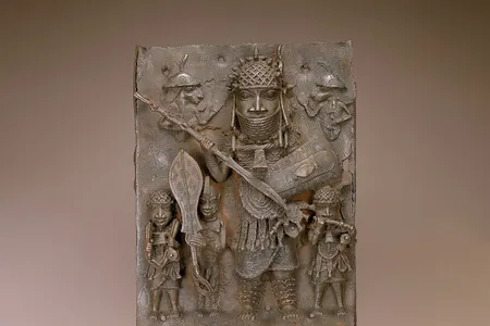 This plaque depicts musicians, a page holding a ceremonial sword and a high-ranking warrior. It numbers among the thousands of works looted by British forces during an 1897 raid of Benin City.