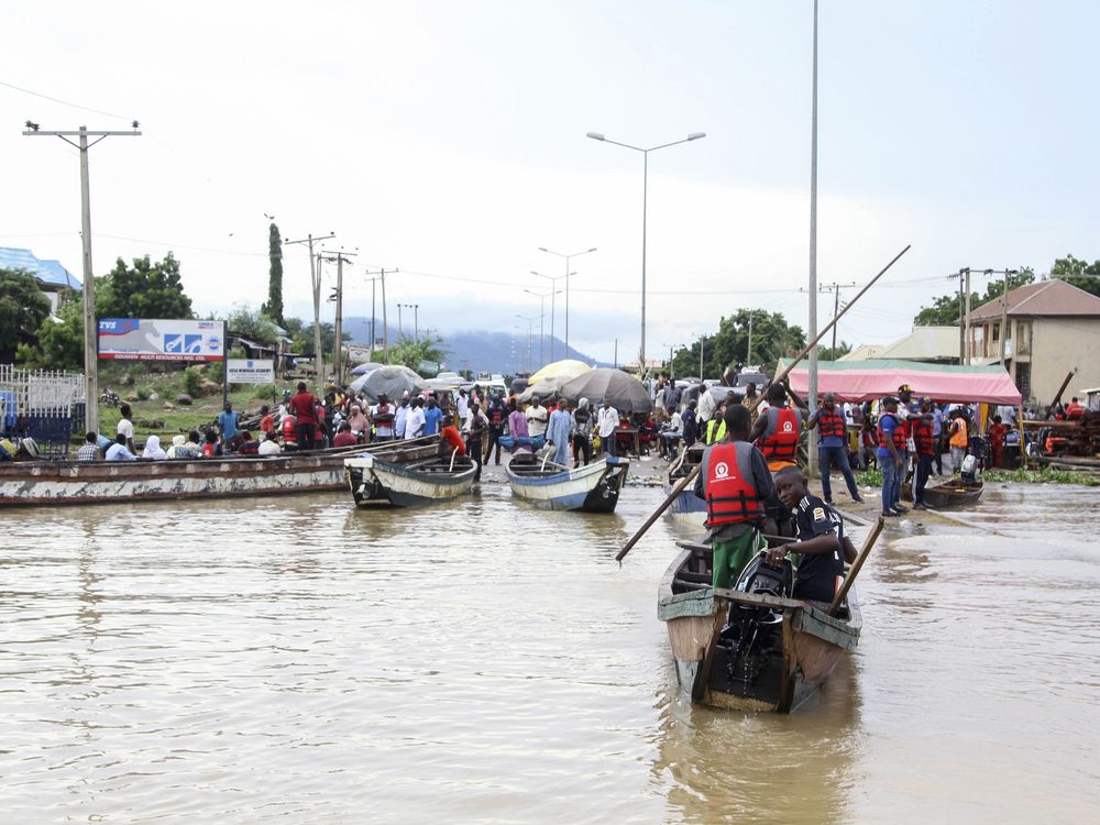 people ride boats through water-covered streets