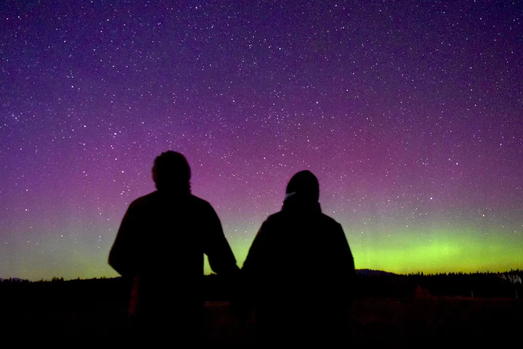 two people are by silhouetted the night sky