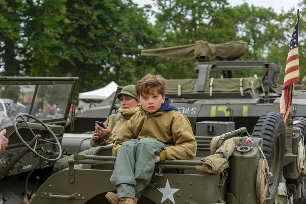 Boy sitting on a military vehicle thumbnail