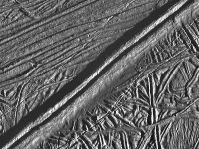 Europa’s surface as seen by NASA’s Galileo probe, with a prominent double-ridge system running from the lower left to the upper right. The feature could function similarly to a mid-oceanic ridge on Earth.