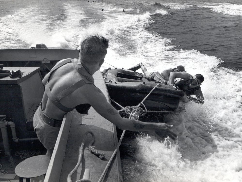 UDT members deploying from a speeding landing craft